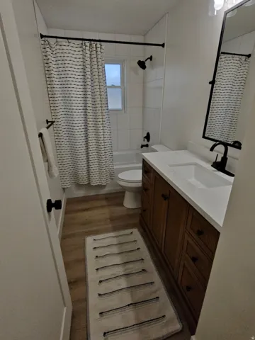 Bathroom featuring a dark wood-finish vanity with ample storage, a white countertop with an integrated sink, and matte black fixtures