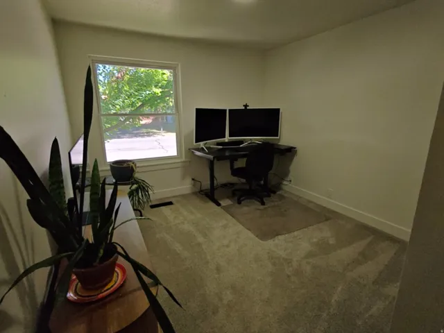 Carpeted room featuring a single window with white trim, baseboards, and neutral wall paint