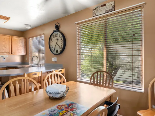 Kitchen dining area featuring wood-finish cabinetry, a stainless-steel sink, and a large window with blinds