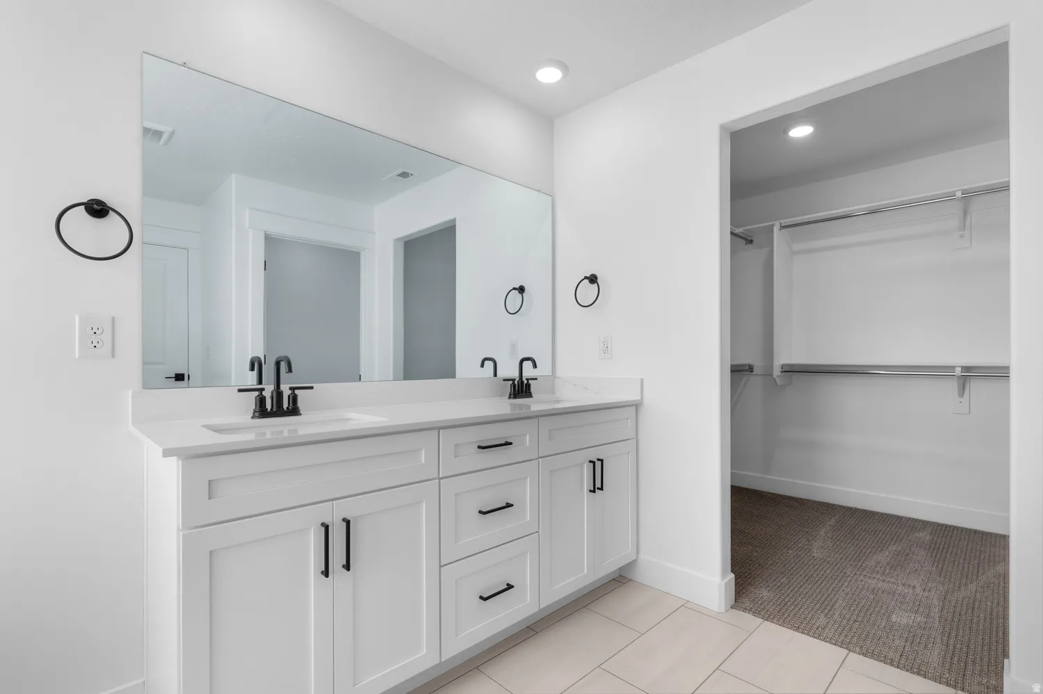 Dual vanity featuring white shaker-style cabinetry, quartz-finish countertop, and matte black fixtures