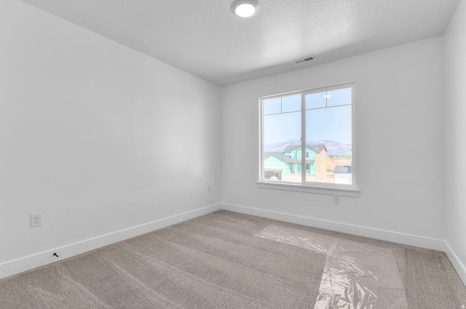 Carpeted room featuring a large window, recessed lighting, and white baseboards