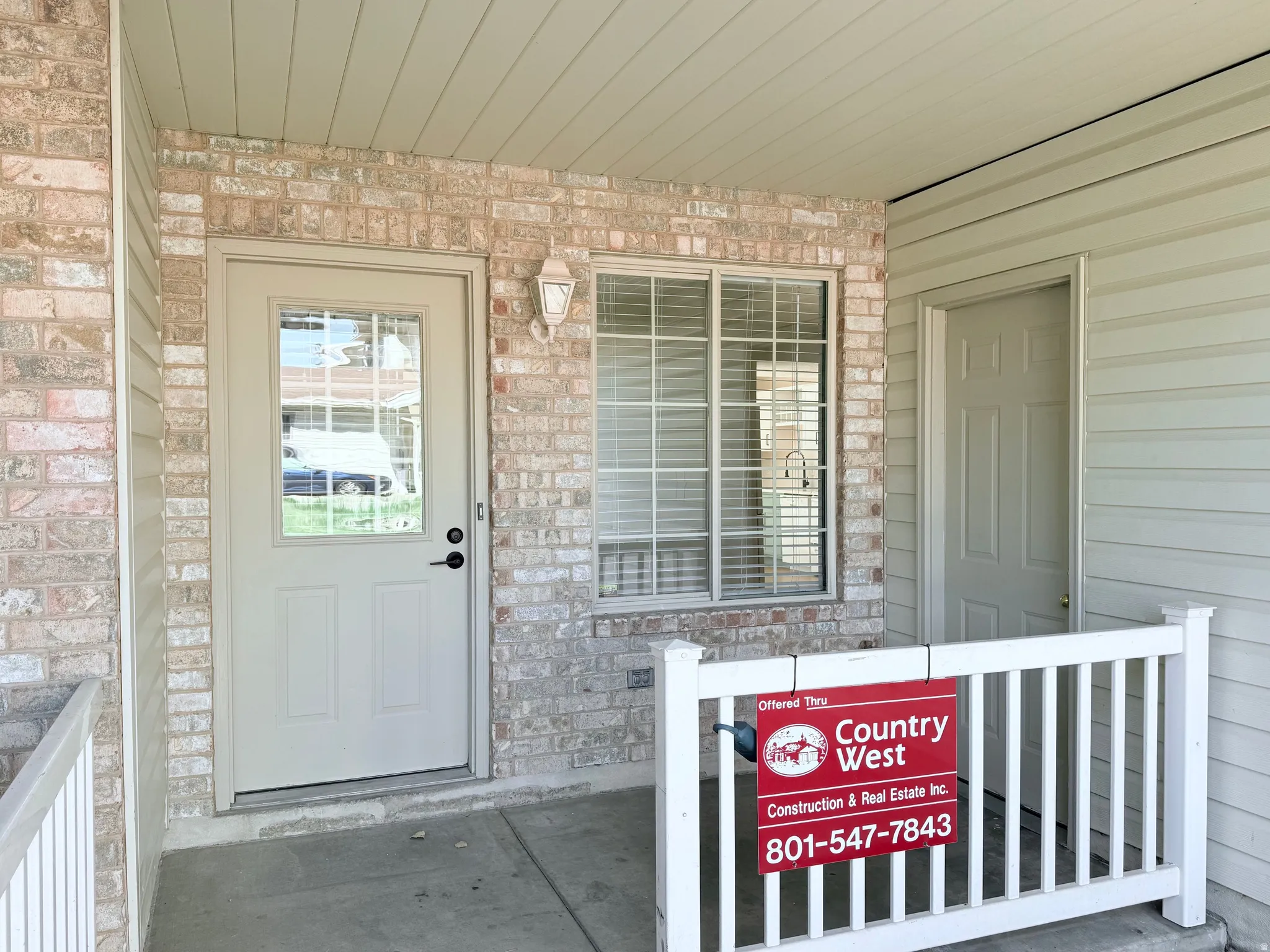 Brick and siding exterior with a covered porch