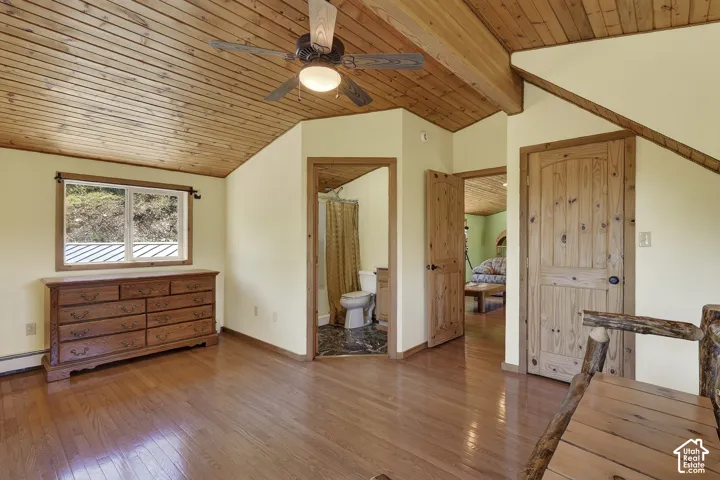 Vaulted wood-paneled ceiling with exposed beams and a ceiling fan