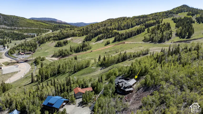Mountain-side property featuring a multi-level structure with a dark roofline