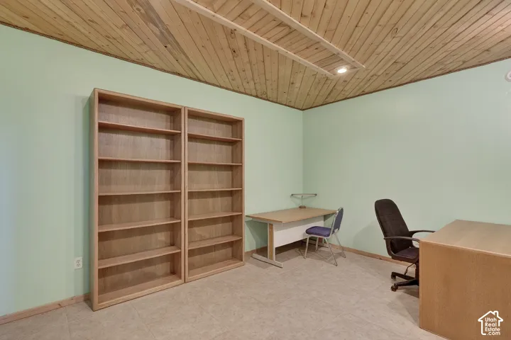 Room featuring a light wood plank ceiling, neutral flooring, and light green walls