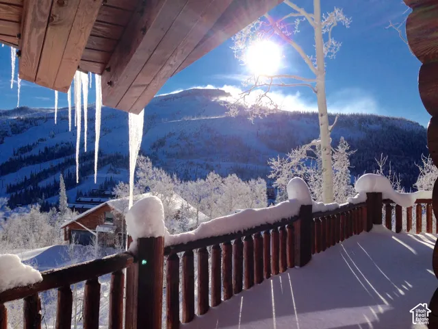 Balcony with rustic wooden railing and substantial overhead beams