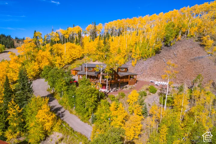 Rustic-style residence situated on a hillside, featuring extensive wrap-around decking and multiple levels