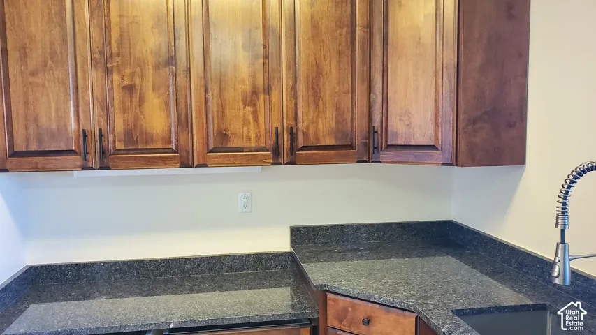 Kitchen featuring rich wood-finish upper cabinetry with dark hardware
