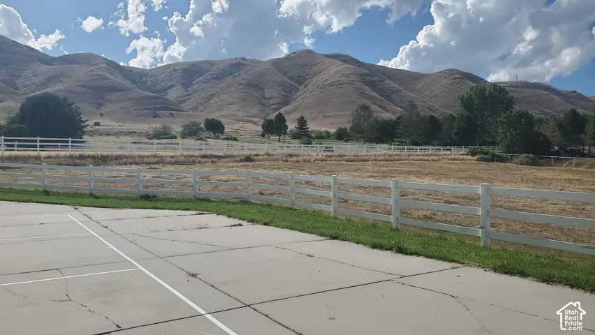 Expansive concrete patio area with a white post-and-rail fence