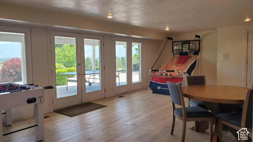 Expansive room featuring light wood-finish flooring, recessed lighting, and multiple French doors