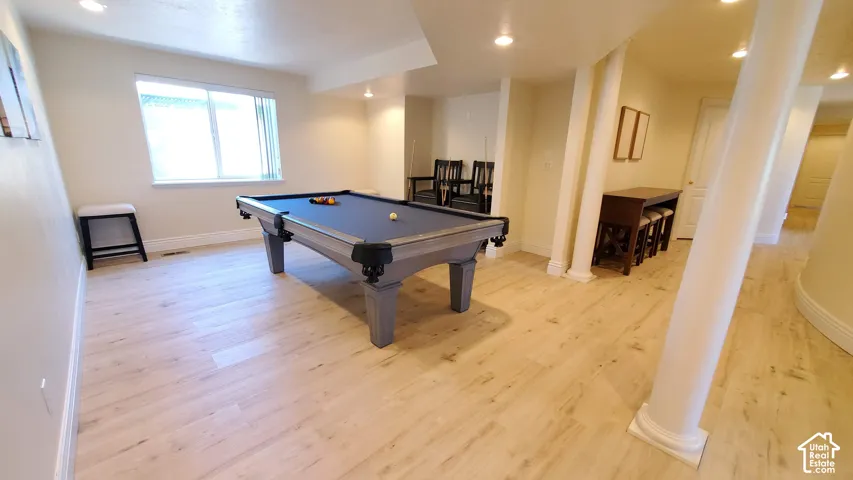 Spacious room featuring light wood-finish flooring and recessed lighting