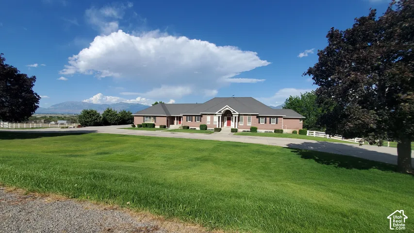 Brick exterior residence with a prominent gabled entry, a dark gray shingled roof, white trim, and a red front door