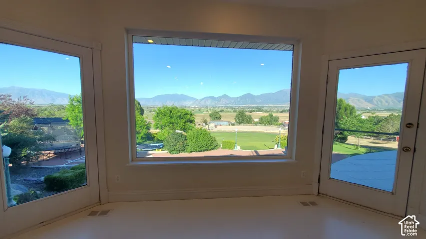 Expansive picture window and two glass-paneled doors offering panoramic mountain and valley scenery