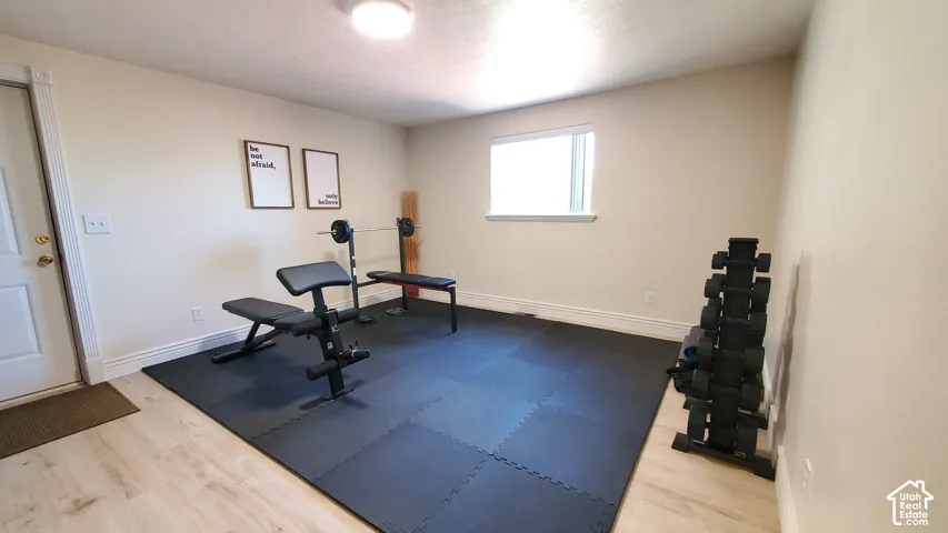 Versatile room featuring light wood-finish flooring, neutral wall tones, and a window for natural light