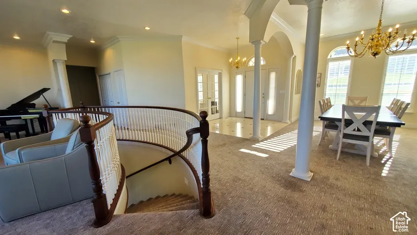 Grand entry featuring a curved staircase with wood newel posts and white spindles, leading to a carpeted upper landing