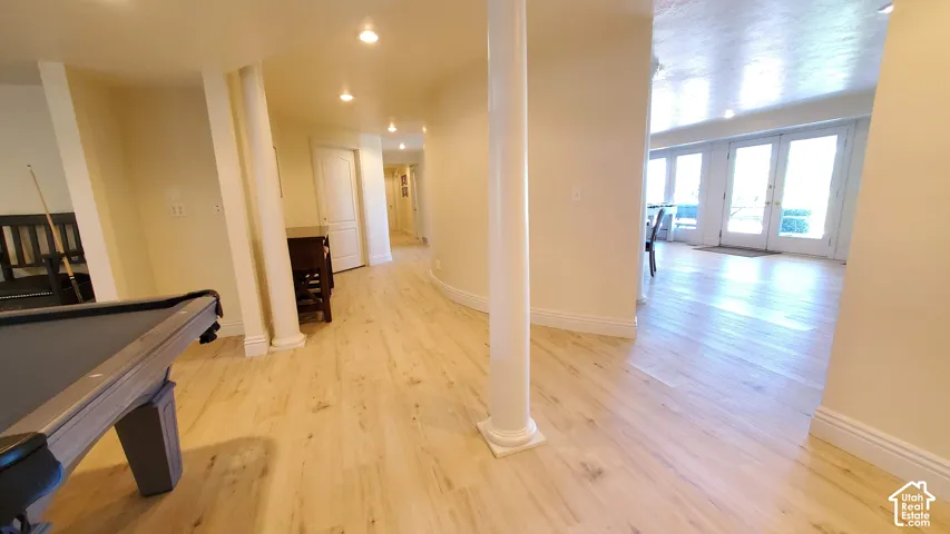 Expansive interior with light wood-finish flooring, recessed lighting, and white baseboards