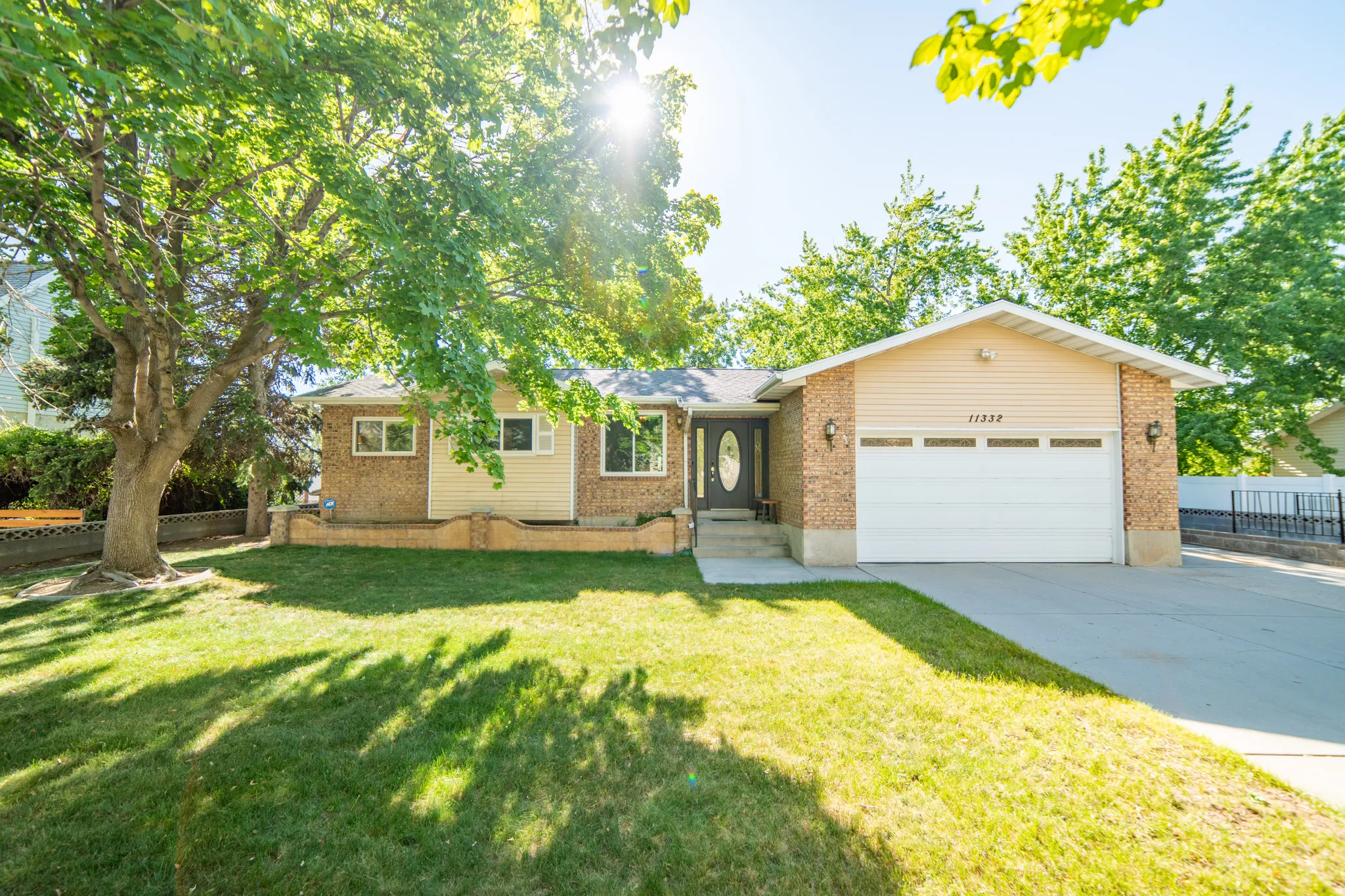 Front exterior featuring a brick facade, attached two-car garage, and a concrete driveway