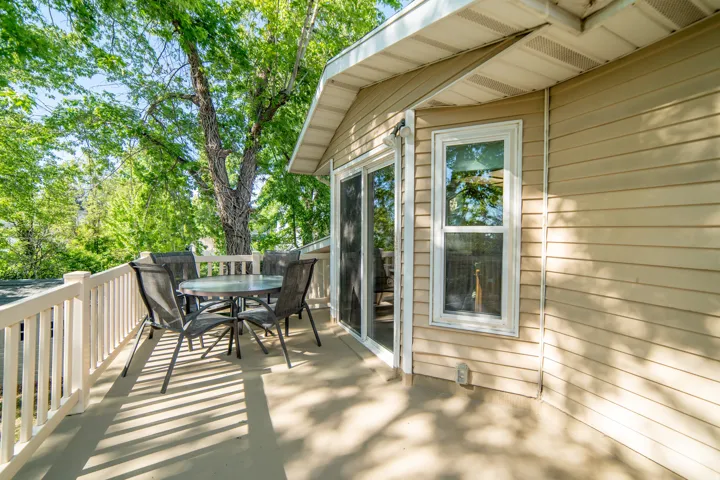 Exterior deck space featuring a light-colored railing and a sliding glass door