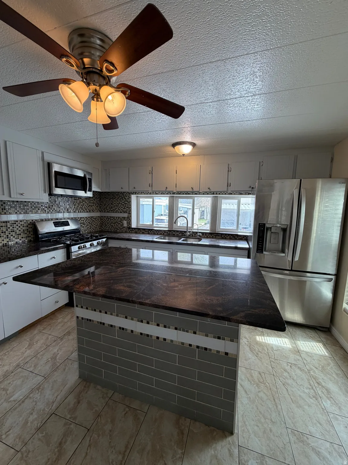 Kitchen featuring white cabinetry, a tiled backsplash, and stainless steel appliances