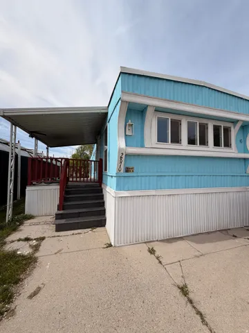 Blue corrugated siding exterior with white trim and white skirting