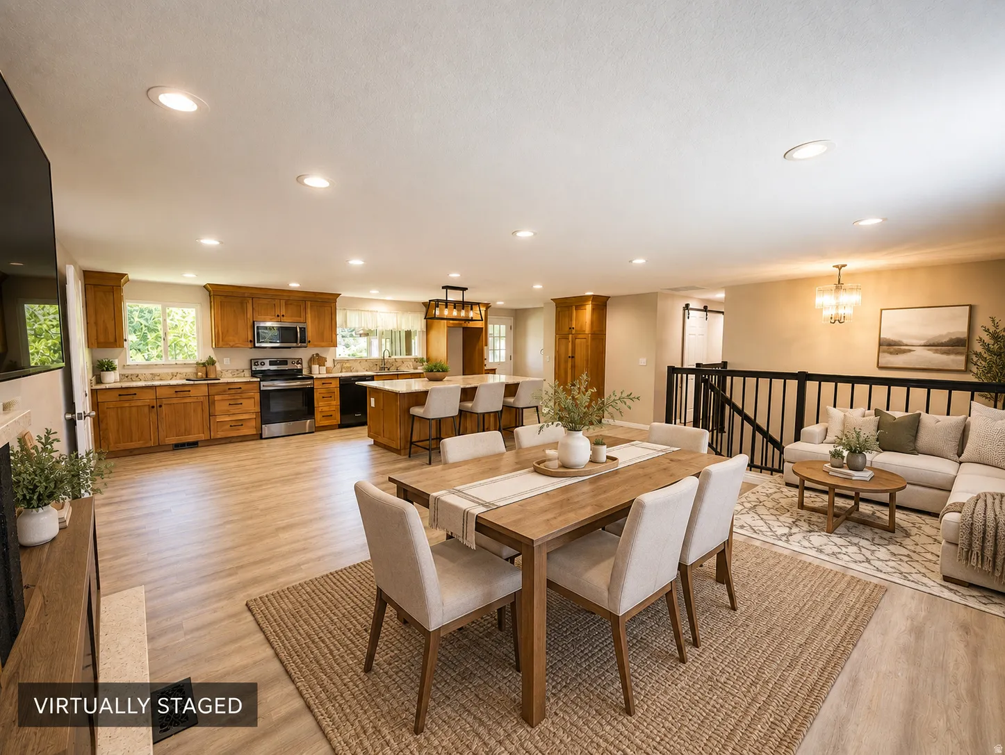 Recessed lighting, wood-finish flooring, wood cabinetry, stainless steel appliances, and a kitchen island with bar seating