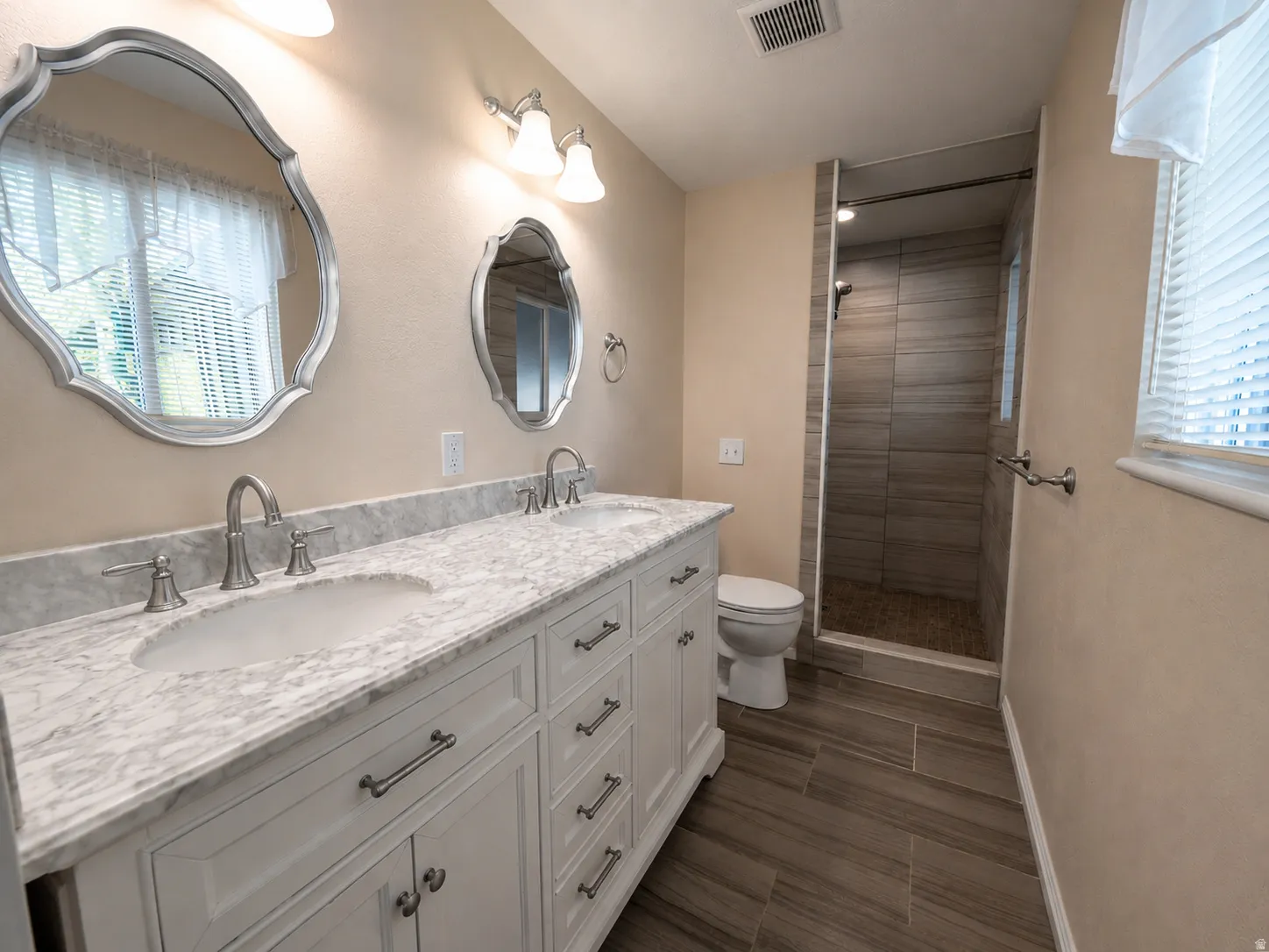 Bathroom featuring a double vanity with white cabinetry, a light-toned countertop, and dual undermount sinks