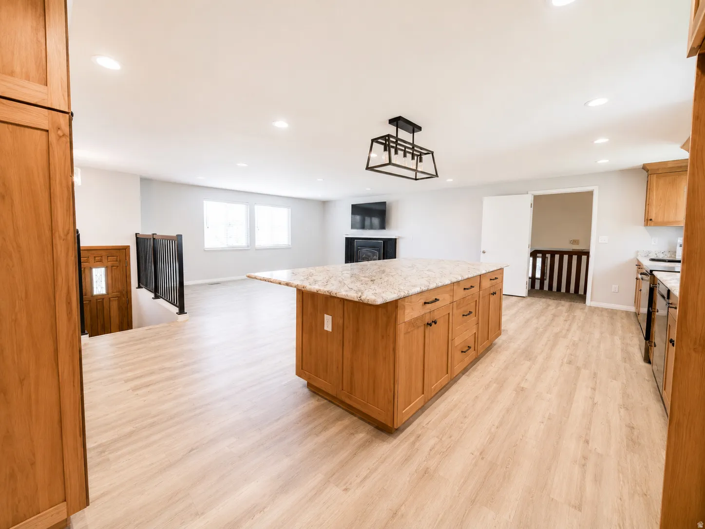 Spacious kitchen island featuring a light-toned countertop, ample storage cabinetry, and dark hardware