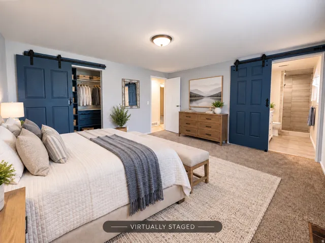 Carpeted flooring throughout, recessed lighting, and two deep blue barn doors