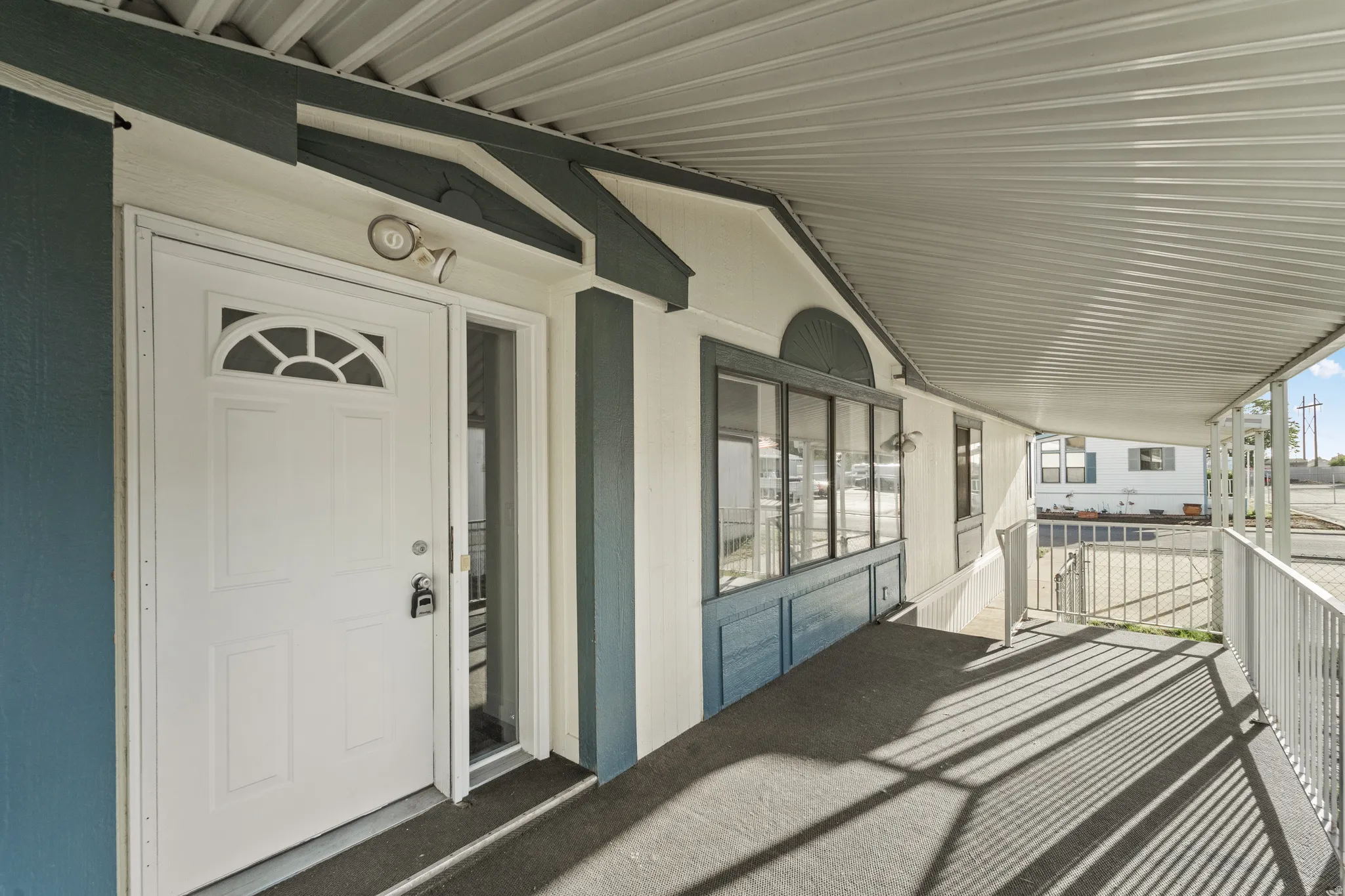 Entryway featuring a white paneled door with an arched glass insert, an exterior light fixture, and a full-length sidelight