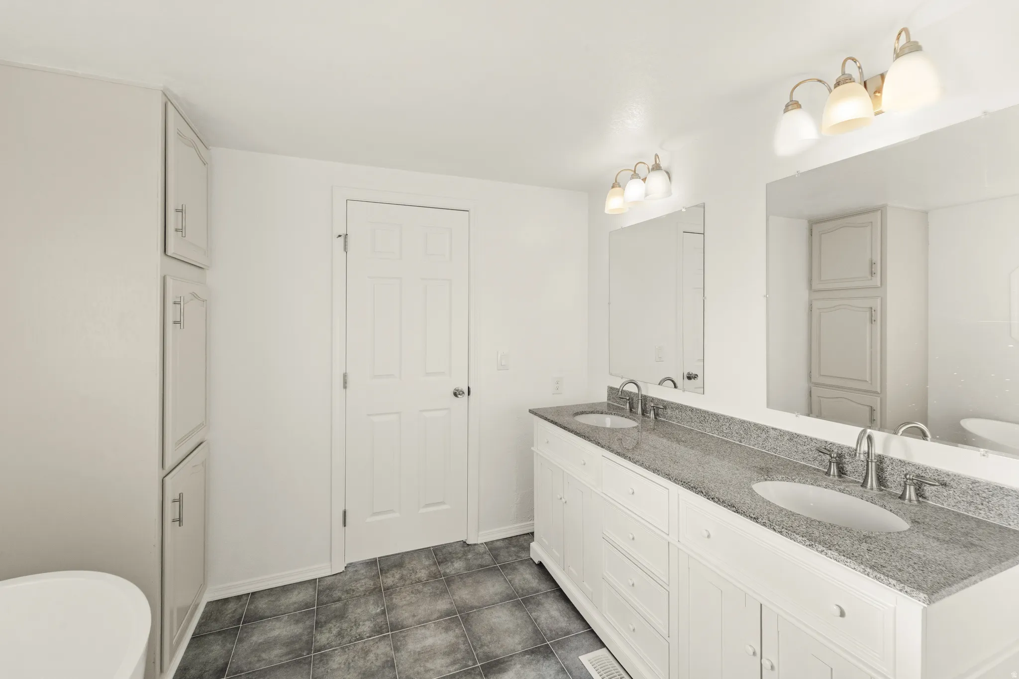 Dual vanity featuring undermount sinks, stone-finish countertop, and brushed nickel fixtures