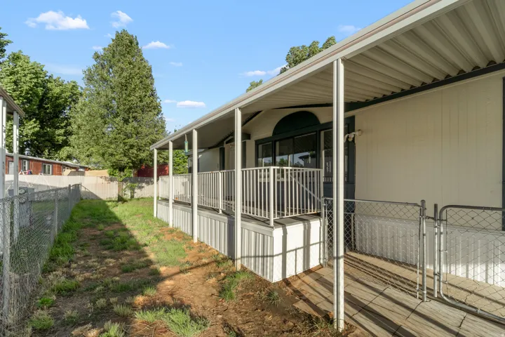 Covered side porch with white railing, glass sliding door, and integrated ramp access