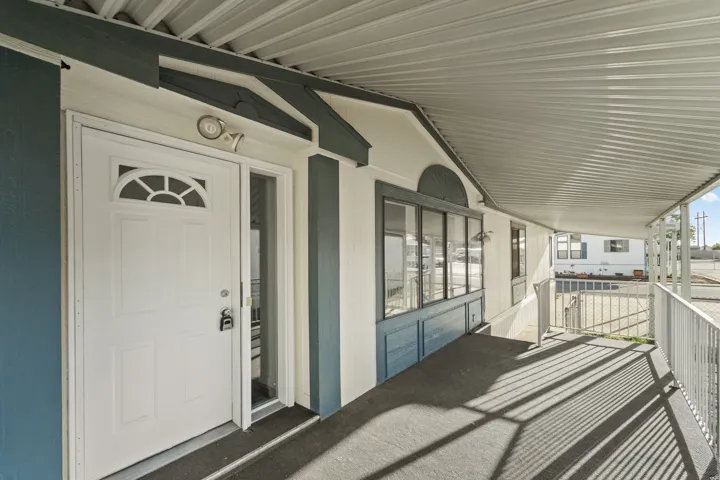 Entryway featuring a white paneled door with an arched glass insert, an exterior light fixture, and a full-length sidelight