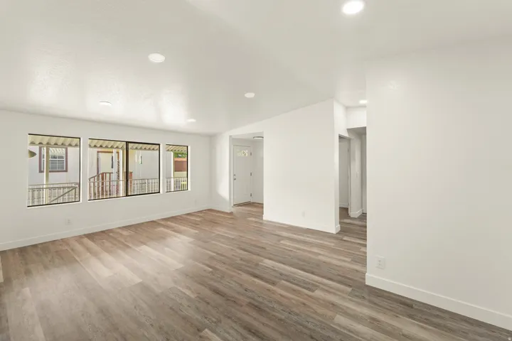 Spacious interior featuring wood-finish flooring, recessed ceiling lighting, and multiple windows
