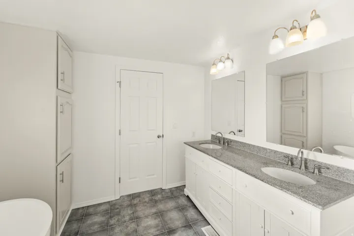 Dual vanity featuring undermount sinks, stone-finish countertop, and brushed nickel fixtures