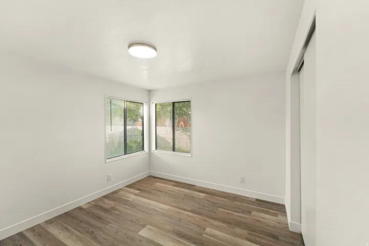 Room featuring wood-finish flooring, white baseboards, and neutral wall paint