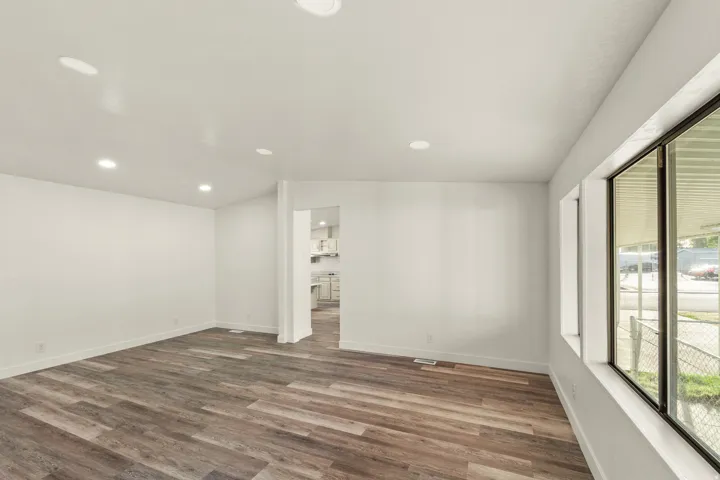 Bright interior featuring wood-finish flooring, recessed lighting, white baseboards, and expansive windows