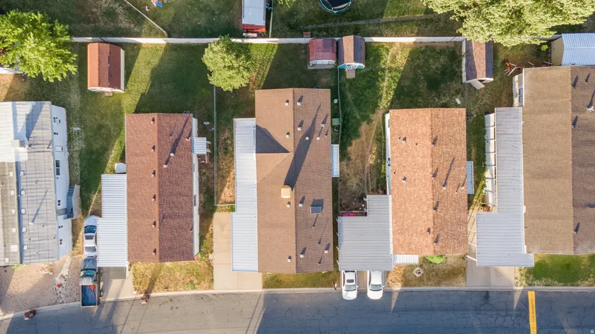 Aerial view showcasing three residential properties with brown shingle roofing