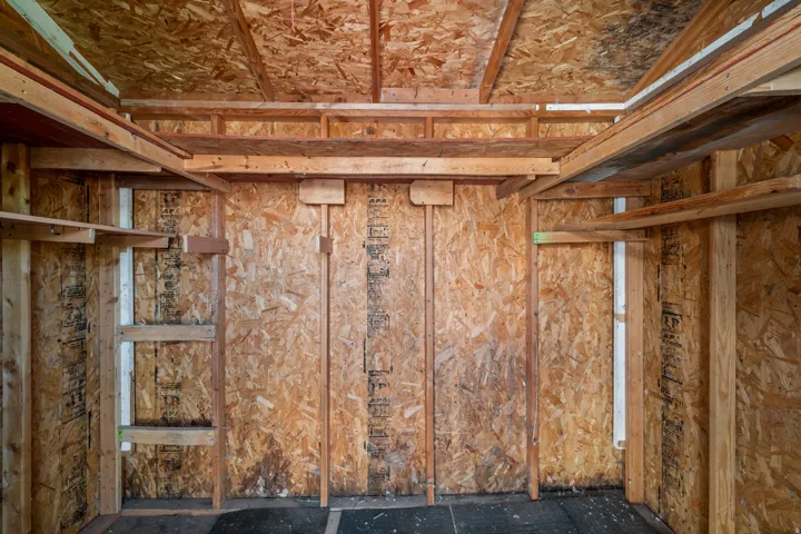 Unfinished interior space featuring exposed wood framing and oriented strand board (OSB) walls