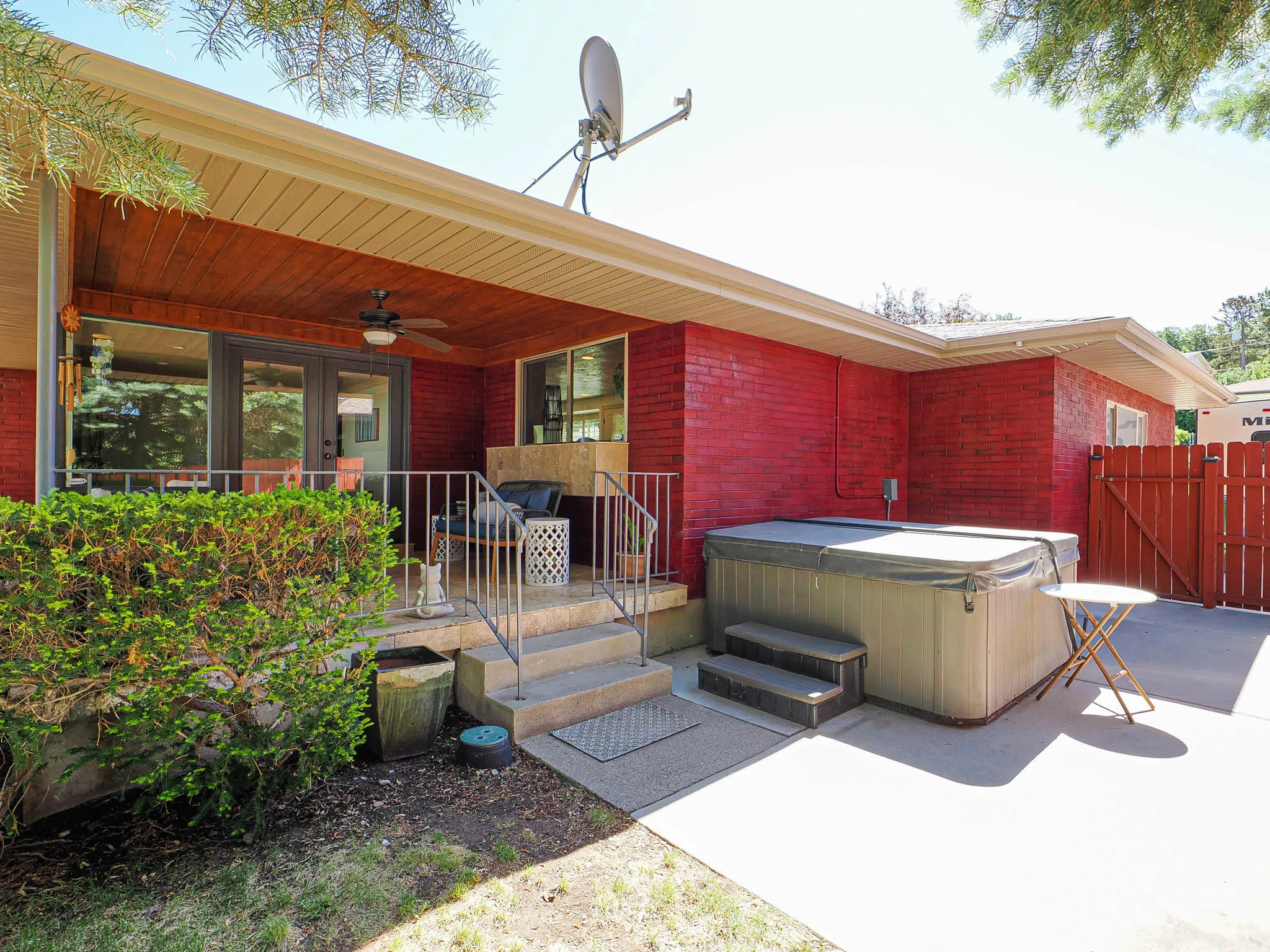 Covered patio featuring wood-finish soffit, ceiling fan, and double-pane glass doors