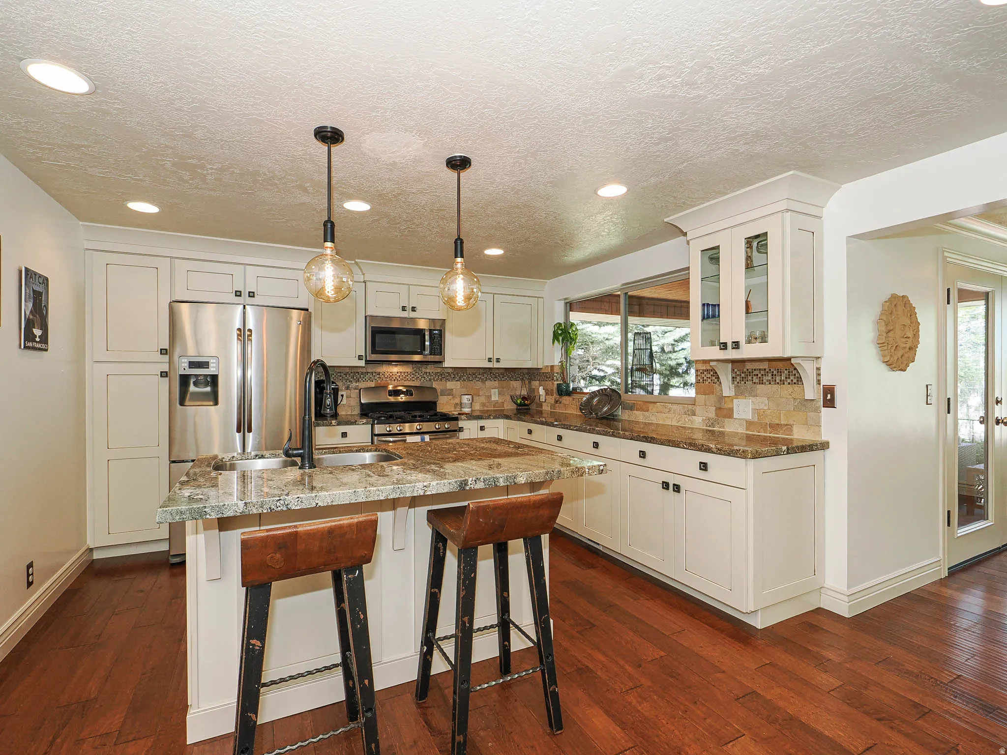 Gourmet kitchen featuring cream-colored cabinetry, stainless steel appliances, and a tiled backsplash
