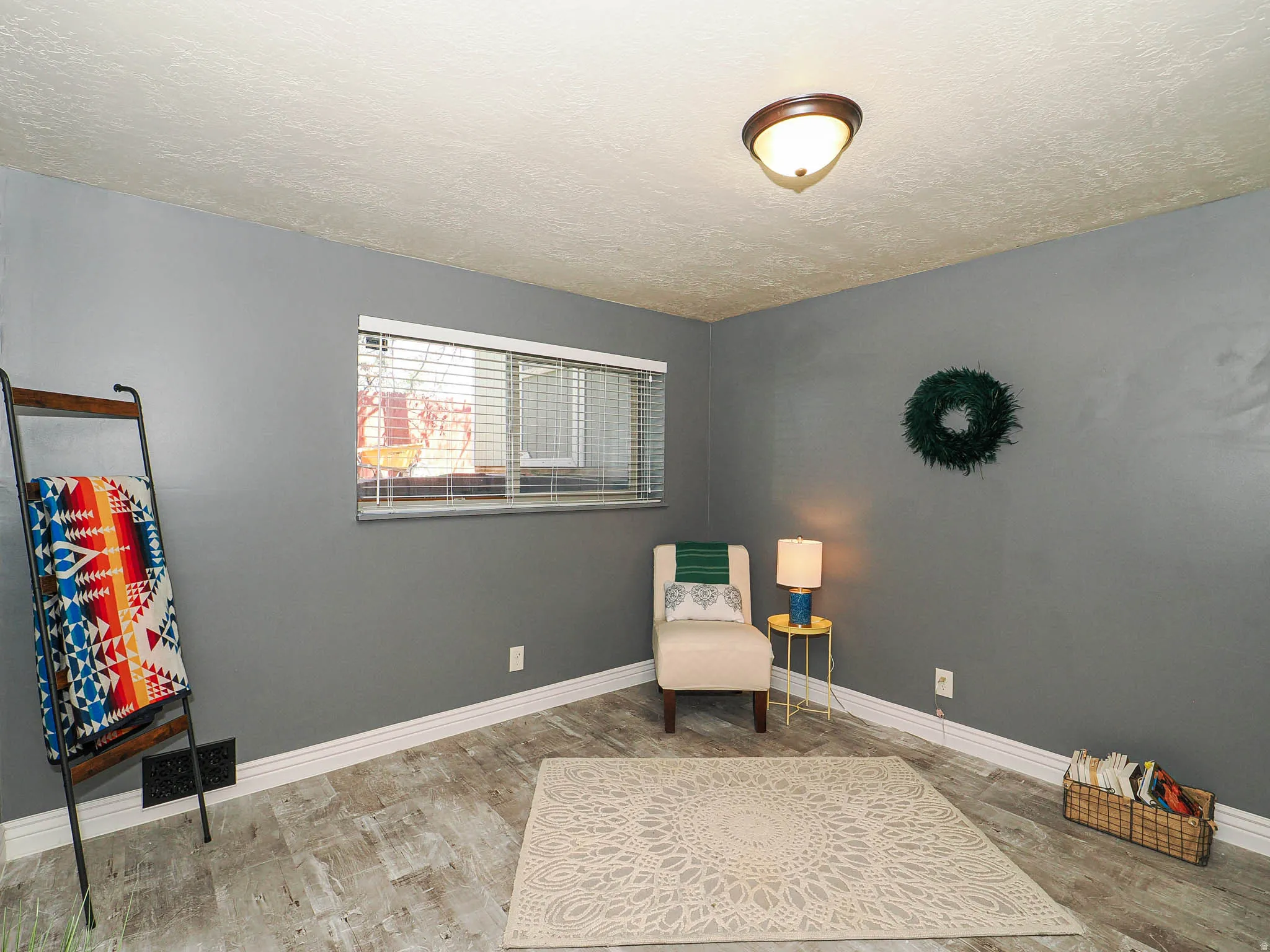 Room with wood-finish flooring, neutral gray walls, and white baseboards