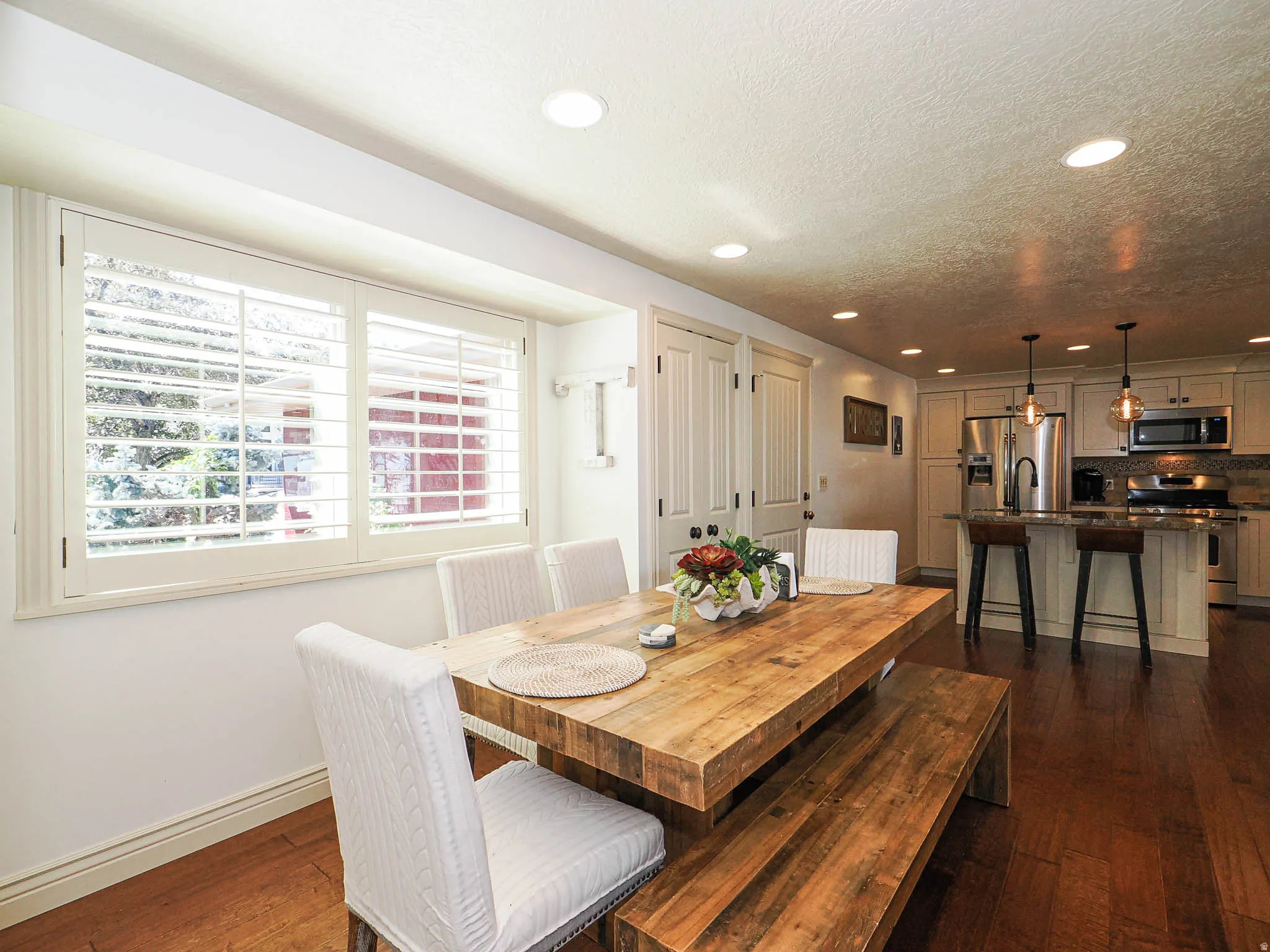 Dining area featuring wood-finish flooring, recessed lighting, and a window with plantation shutters