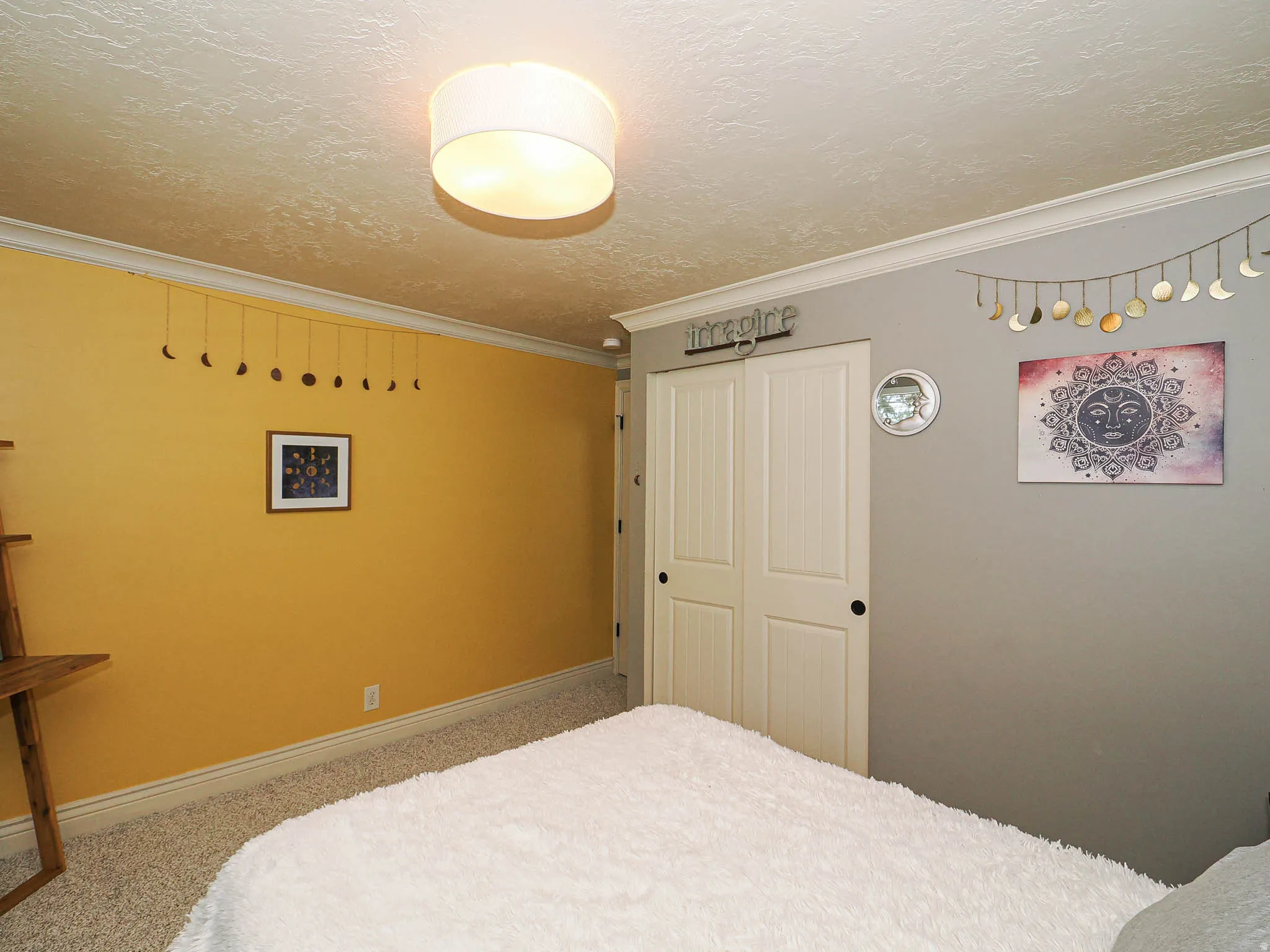 Interior room with a textured ceiling, crown molding, and two-tone wall paint