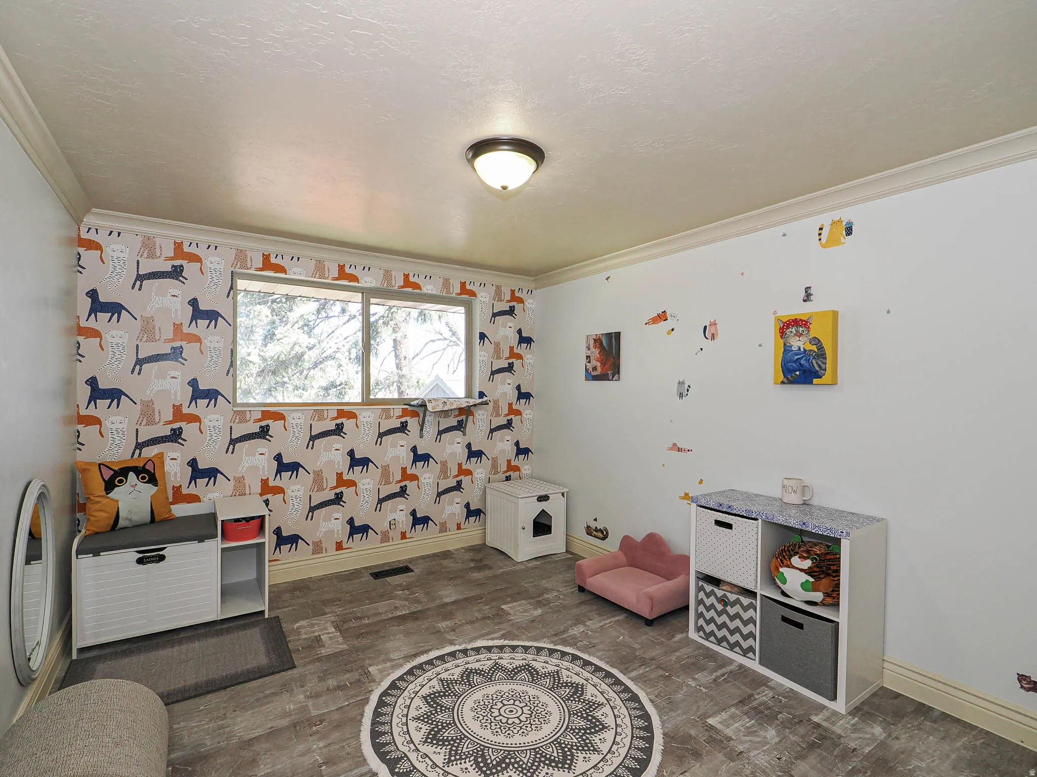 Bright room featuring wood-finish flooring and crown molding