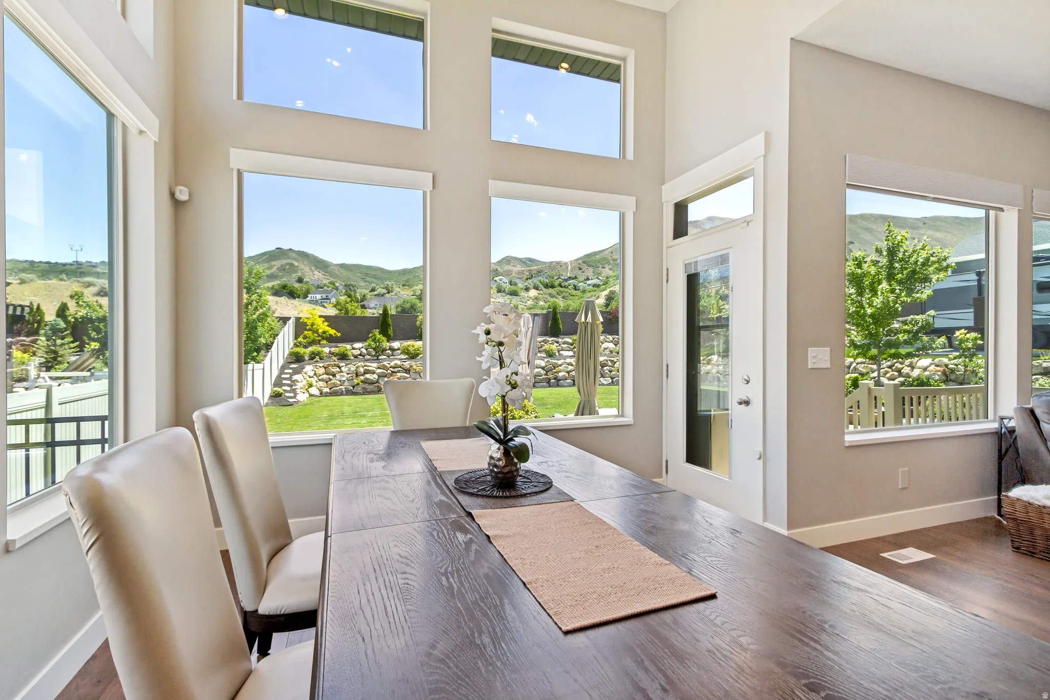 Great room featuring a tall ceiling, extensive windows, a full-light exterior door, and wood-finish flooring