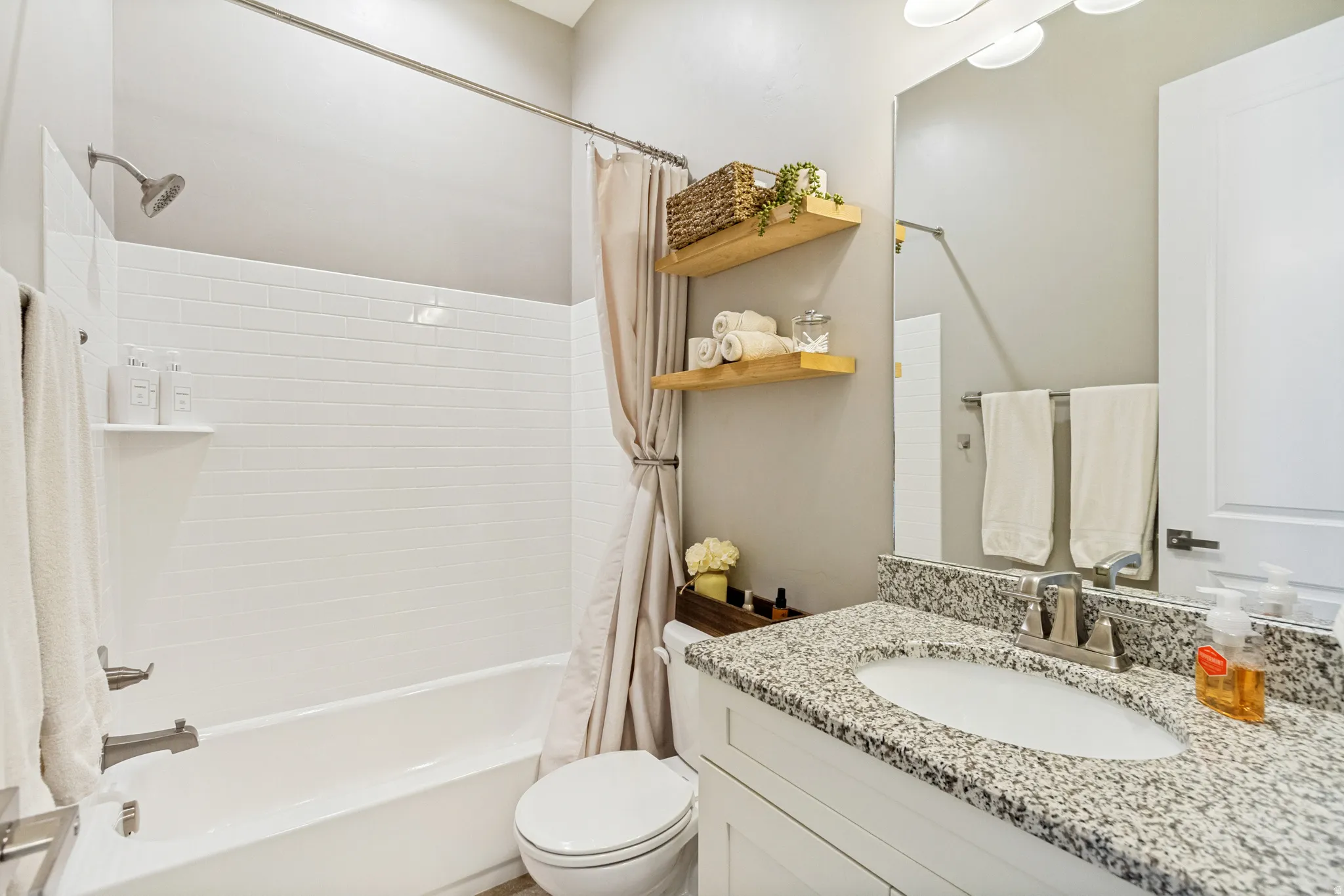 Bathroom featuring a white subway tile shower surround with a built-in shelf
