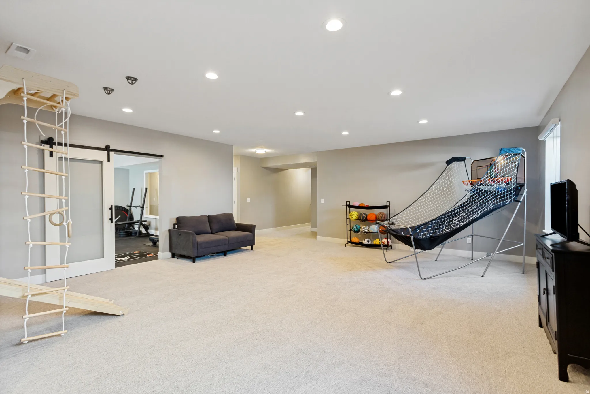 Spacious room featuring light-toned carpeting and recessed lighting