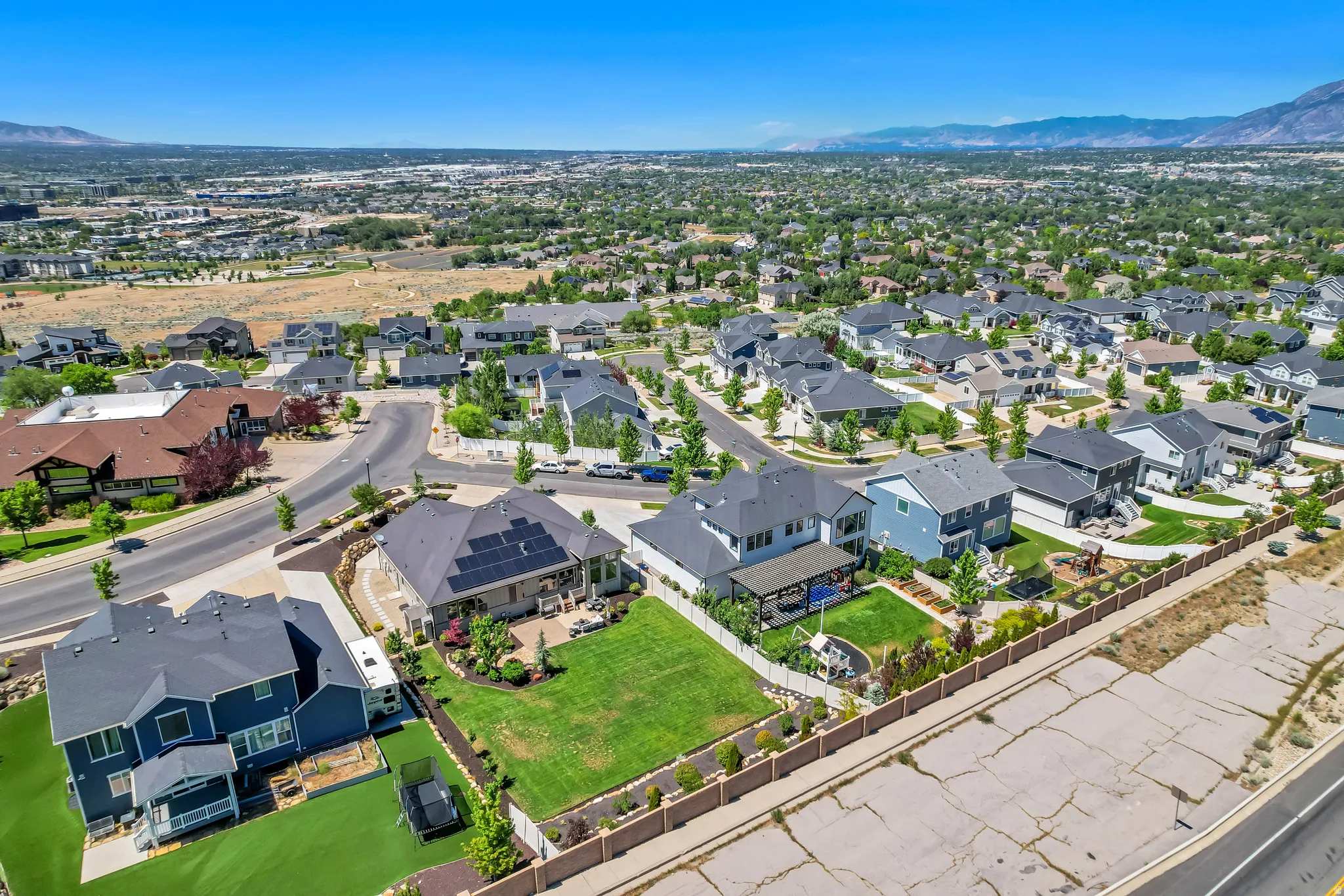 Residential development featuring contemporary homes with dark shingle roofs and green landscaping