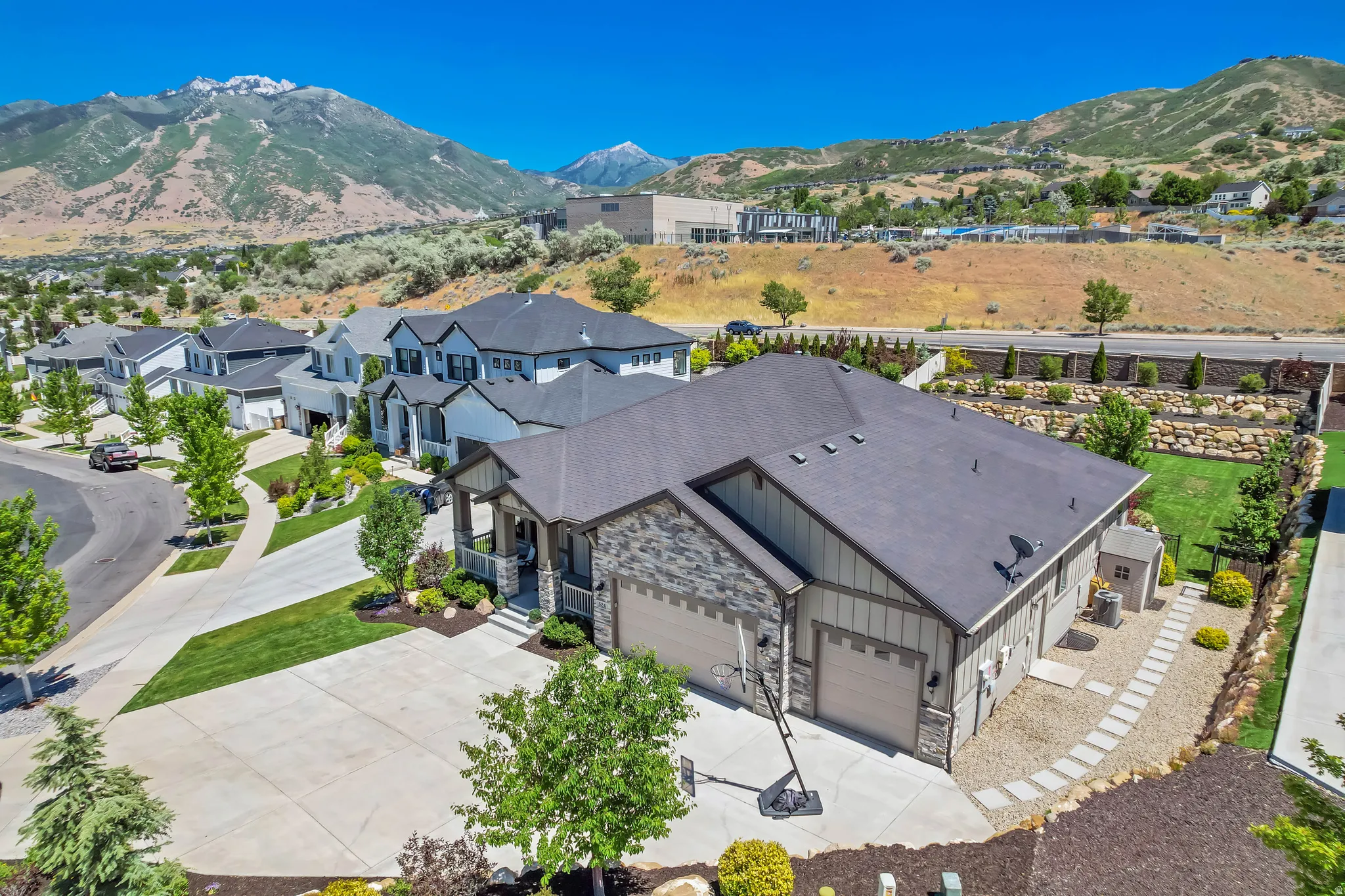 Contemporary single-story residence with a stone and siding exterior, featuring a covered front porch and an attached two-car garage