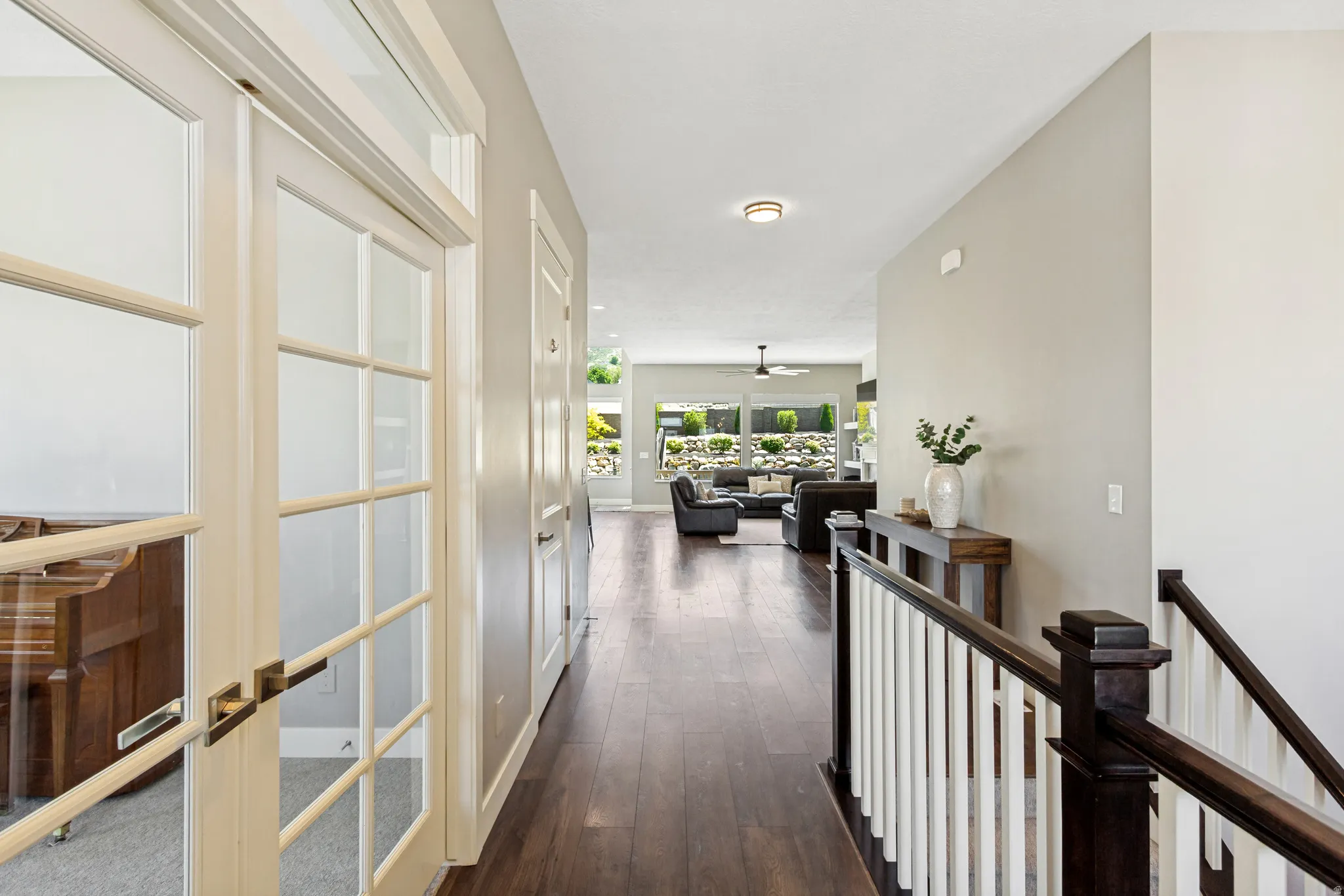 Entryway featuring rich wood-finish flooring and a staircase with dark wood handrails and white balusters